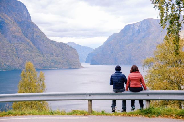 Pictured are two people enjoying a view of a fjord in Norway.