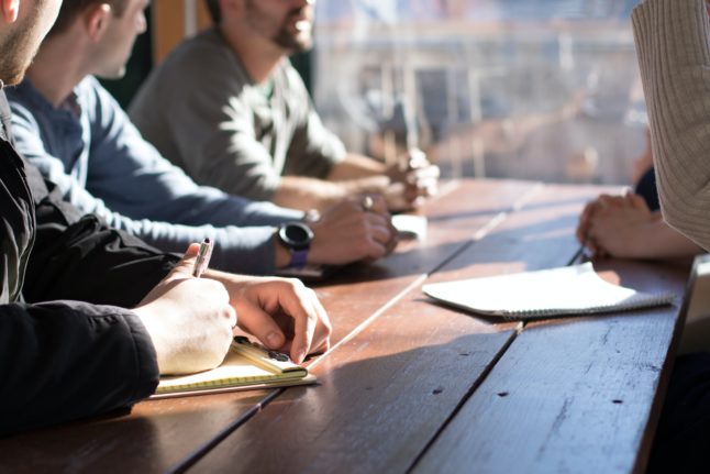 Pictured are workers in a meeting.