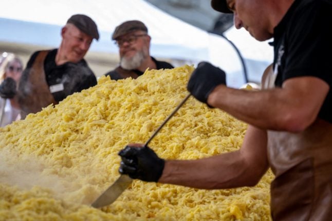 Chefs cook during a record attempt of the world's largest rösti during an event marking the 125th anniversary of the Swiss Farmers' Union in Swiss capital Bern, on September 19, 2022.