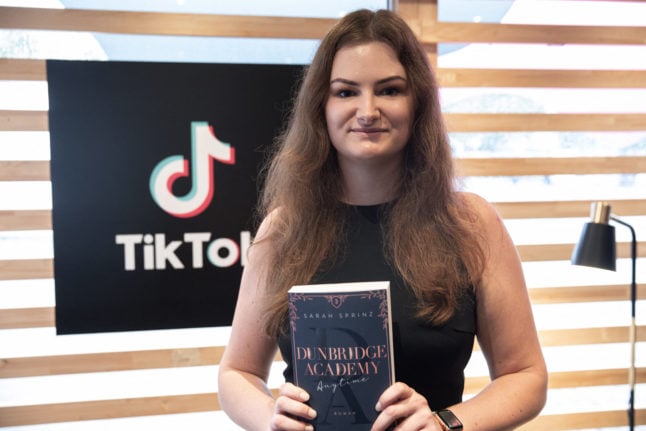 German Author Sarah Sprinz poses for a picture with her book at the TikTok Stands during the 23rd Frankfurt Book Fair