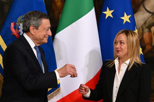 Italy's outgoing prime minister, Mario Draghi hands over the cabinet minister bell to Italy's new prime minister, Giorgia Meloni,
