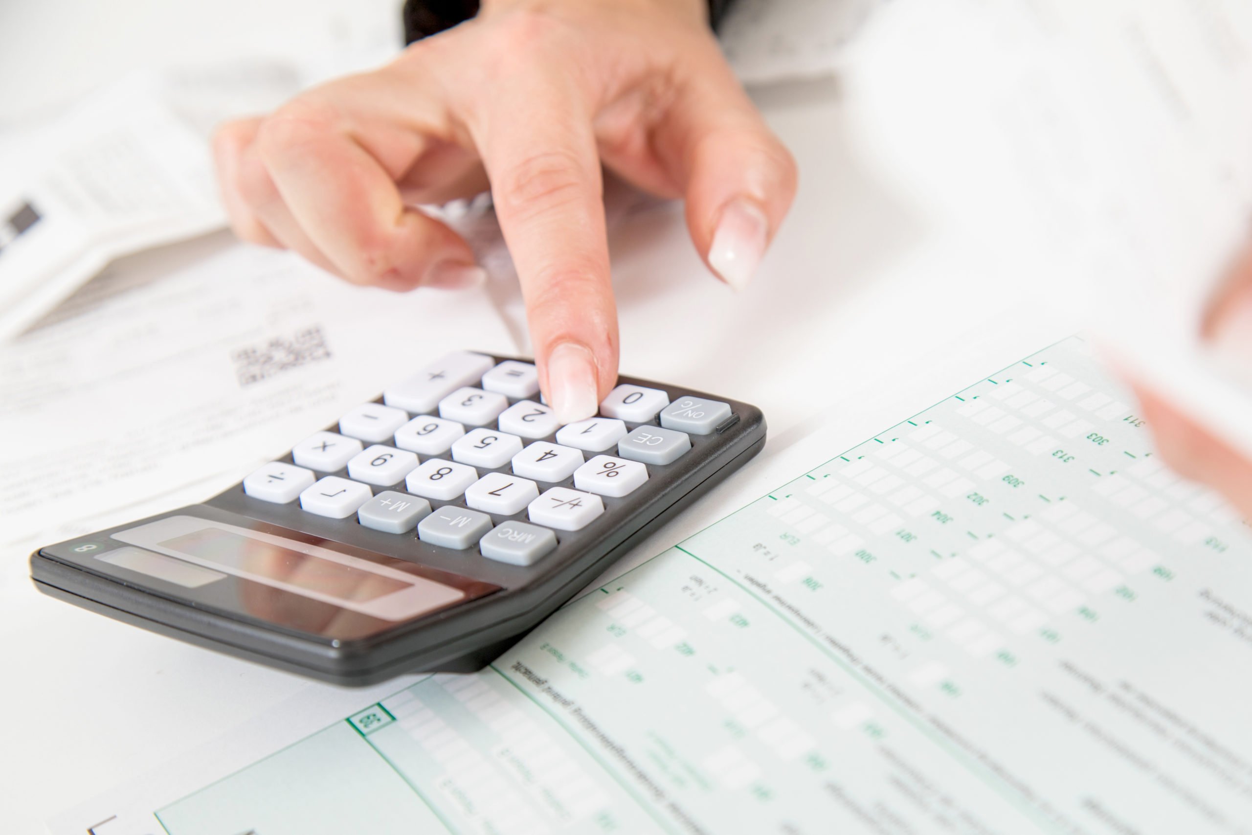 A person types on a calculator.