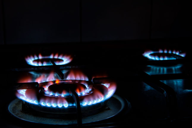 Three lit hobs on a gas oven