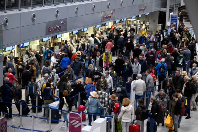 Travellers stand in line at the Eurowings check-in counter at Düsseldorf Airport on Monday, where several flights are cancelled in the strike.