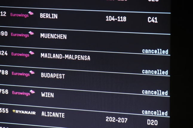 A departure board shows cancelled flights at Cologne/Bonn airport.
