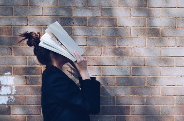 Girl with a textbook on her head in despair