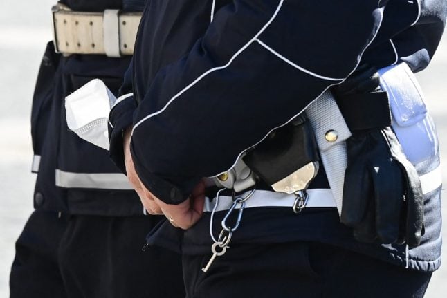 A police officer holds a face mask in his hand