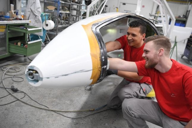 Two light aircraft builders instal the controls on a glider.