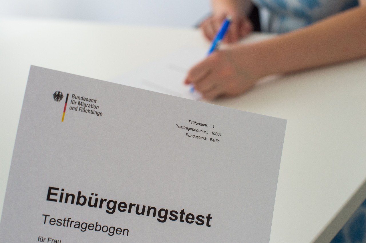 A woman holds German citizenship test.