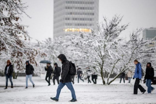 Local residents walk in the snow in Geneva on December 9, 2022.