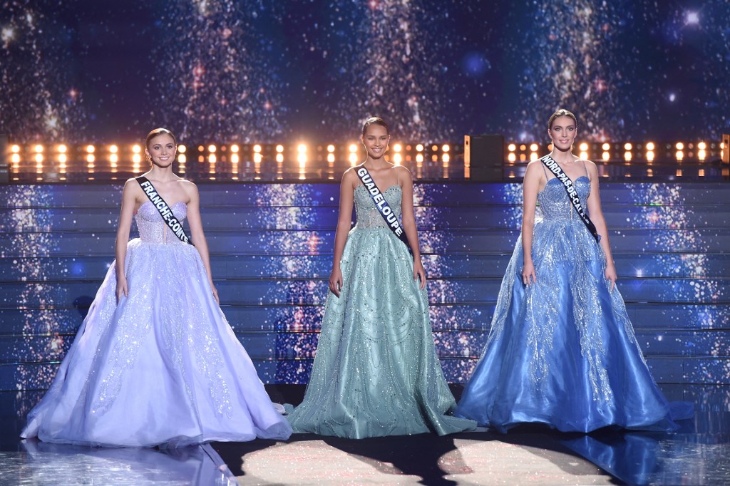 (From L) Miss Franche Comte-Marion Navarro, Miss Guadeloupe Indira Ampiot and Miss Nord-pas-de-Calais Agathe Cauet perform on stage during the Miss France 2023 beauty contest
