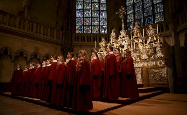 Members of the Regensburger Domspatzen girls' choir sing during their first appearance during a service at the Regensburg Cathedral