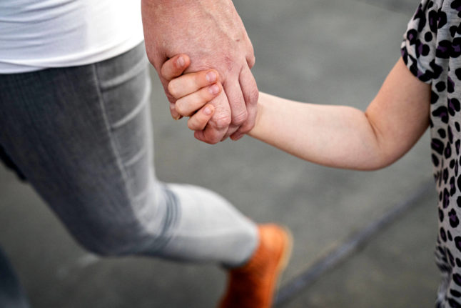 A father holding a child's hand
