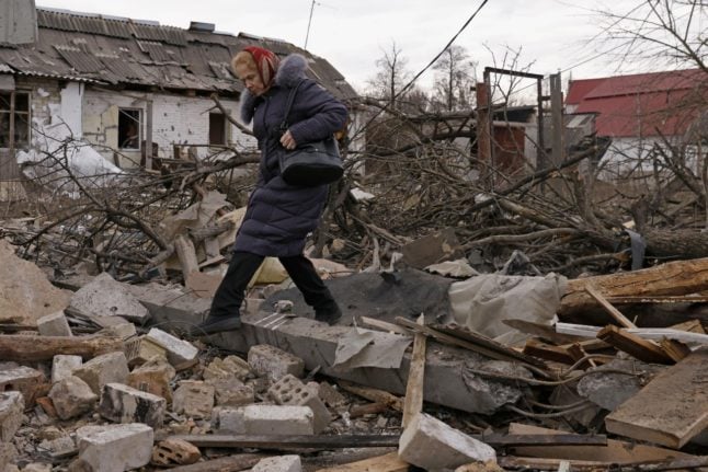 A woman steps over rubble in Kyiv, Ukraine. 
