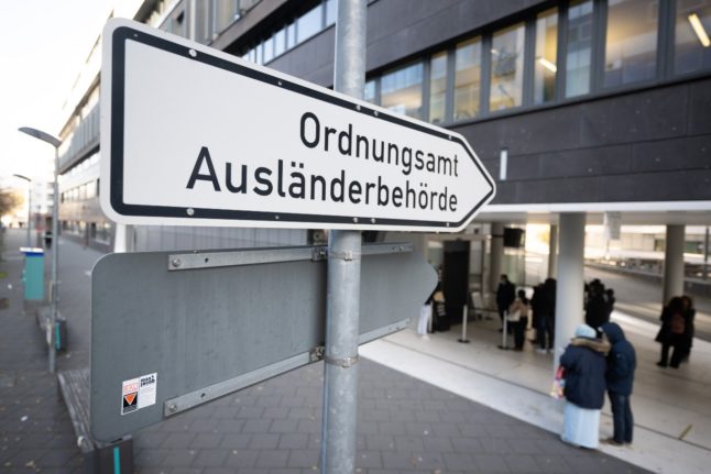 A sign points to the Foreigners Authority and the Public Order Office of Frankfurt am Main.