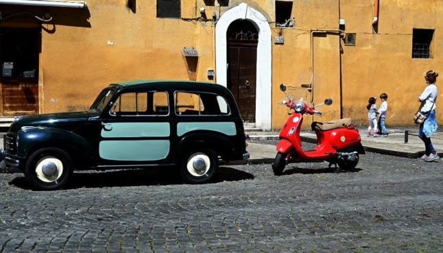 Red Vespa motorcycle and vintage Fiat