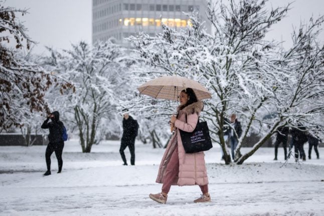 Local residents walk in the snow in Geneva on December 9, 2022.