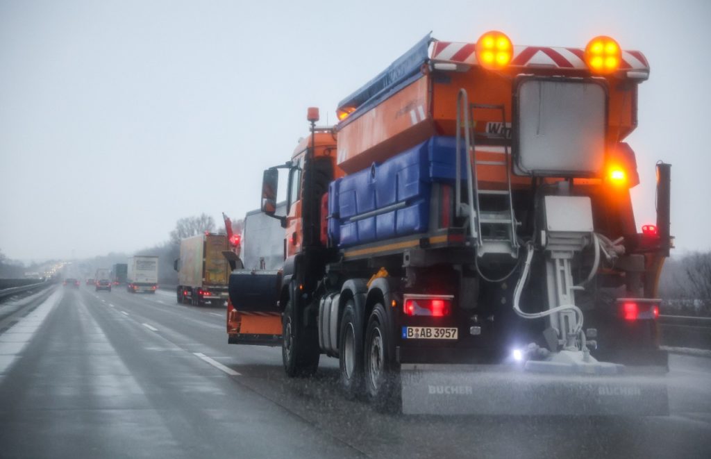 A gritting vehicle from the winter road clearance service drives on highway 9 in Saxony and spreads salt on the roadway.