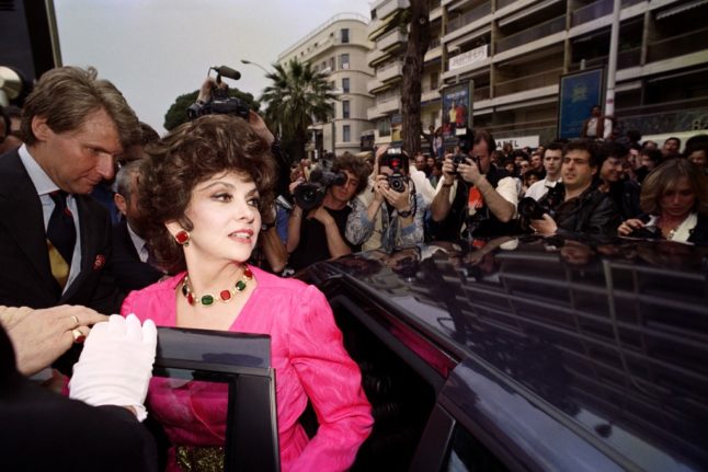 Italian actress Gina Lollobrigida stands next to a car during the 44th Cannes Film Festival in Cannes, southern France on May 11, 1991.