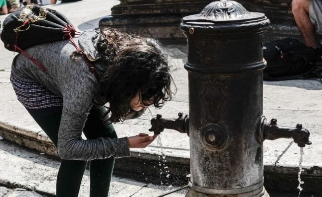 A woman drinks from one of Rome's fountains. 