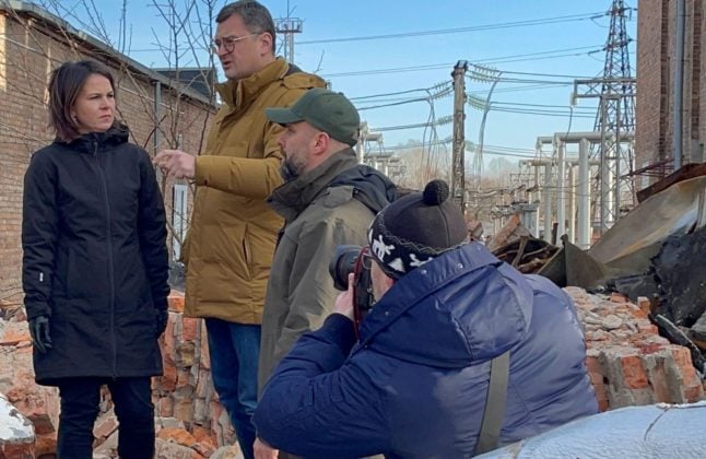 Foreign Minister Annalena Baerbock stands next to Ukrainian Foreign Minister Dmytro Kuleba (3rd from right) and Kharkiv Governor Oleh Synehubov on the site of a substation destroyed by Russian military during her trip to eastern Ukraine.