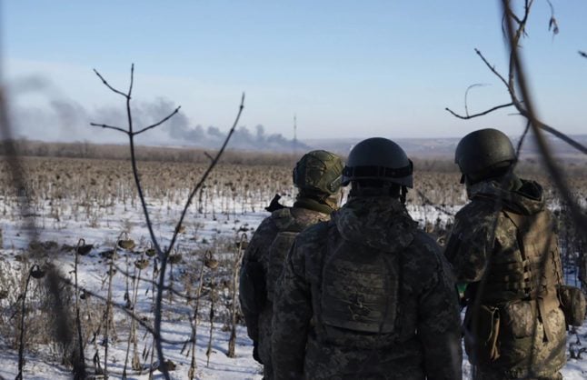 Ukrainian soldiers look out over the battlefield at Soledar