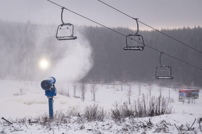 A snow cannon is in operation next to the Hexenritt chairlift on the Wurmberg in the Harz Mountains.