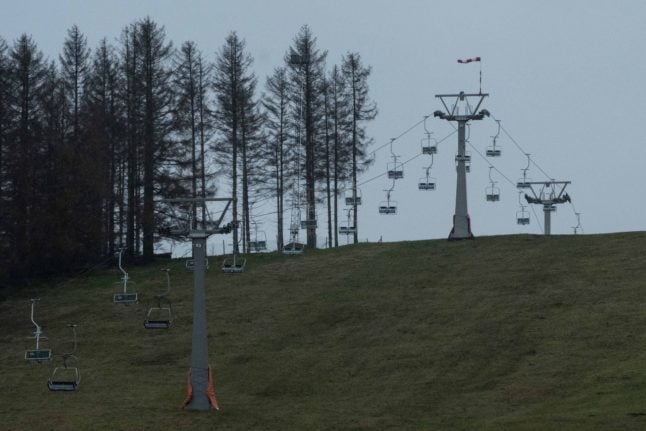 The cable car in the ski resort in the Harz Mountains in Lower Saxony above a meadow where there is no snow.
