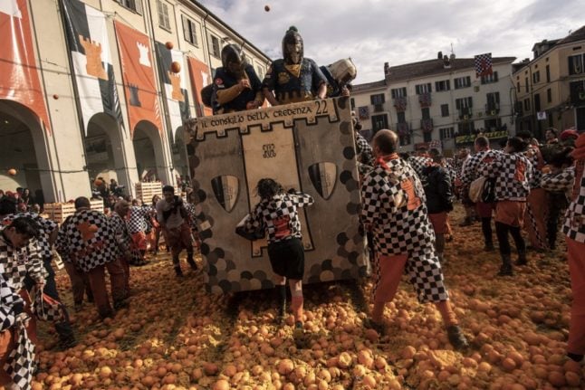 Members of orange battle teams throw oranges at each other during the traditional "Battle of the Oranges" festival held during the carnival in Ivrea, near Turin, on March 3, 2019.