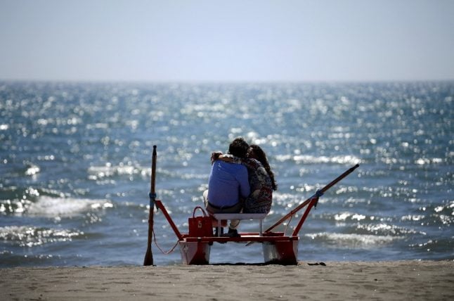 A couple kiss as they enjoy a private beach in Fregene, northwest of Rome.