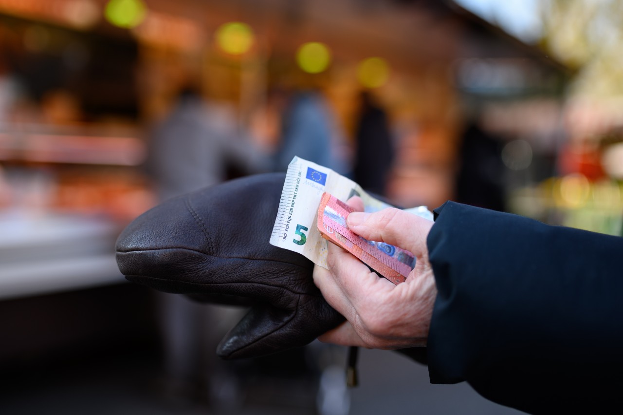 A woman checks money in her wallet while shopping.