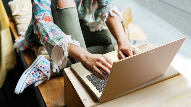 A woman composes a letter on a laptop.