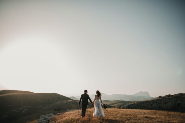 Two newlyweds in a field in Italy