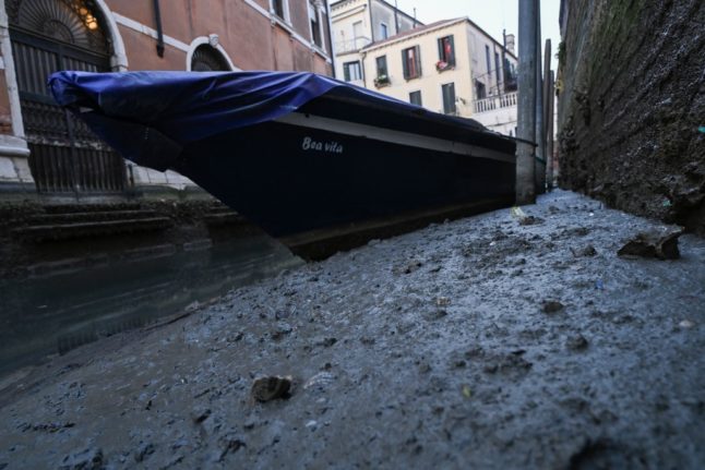 A dried-up canal in Venice and the bow of a gondola