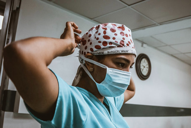 A female surgeon ties her scrub cap