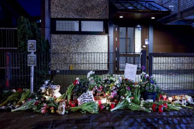 Flowers and candles are seen on March 11, 2023 in Hamburg at the site where several people were killed in a shooting in a church