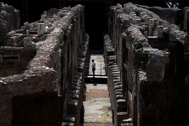 A visitor stands in the hypogeum, or underground area, of the Colosseum.