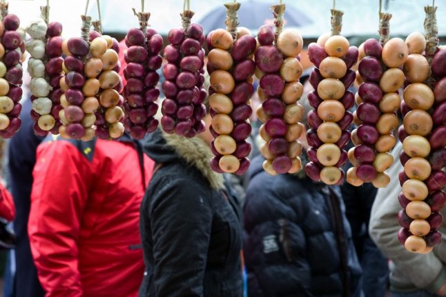 Visitors stand behind chains of onions during the traditional one-day Zibelemarit (onion market).