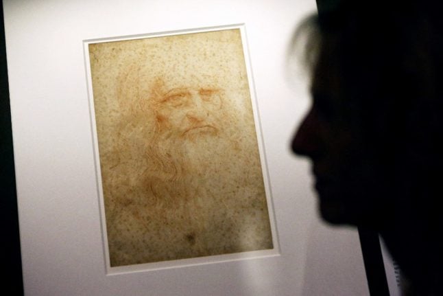 A person stands next to a self-portrait of Leonardo Da Vinci at the Biblioteca Reale in Turin.