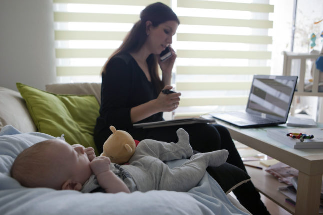 A working mother works at home with her young child. Most part-time workers in Germany are women.