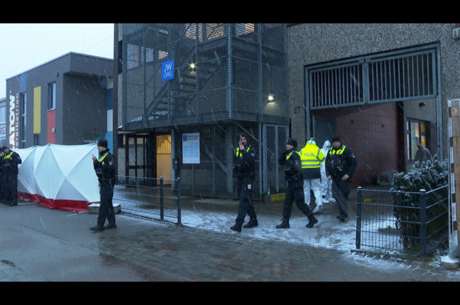 Police officers stand in front of a Jehovah's Witness building in Hamburg. Shots fired at a Jehovah's Witnesses event killed several people and injured some on Thursday evening.