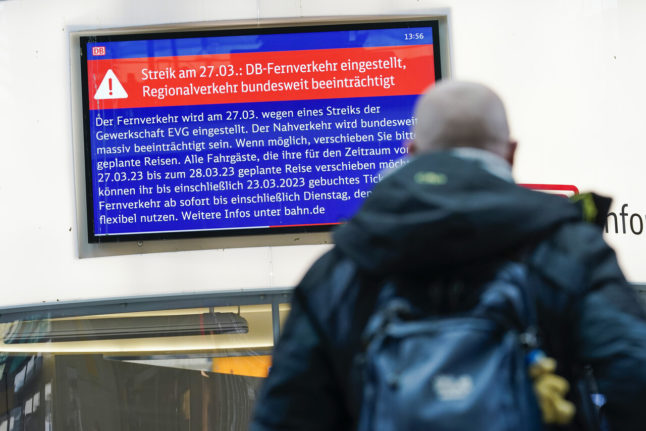 A man looks at a monitor in the main train station in Mannheim, which informs passengers about Monday's rail strike.