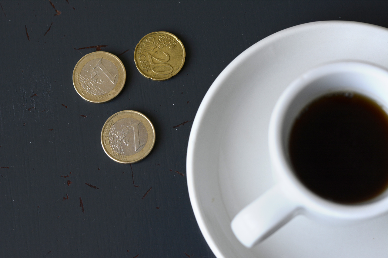 Coins lie next to a coffee cup on a table in a cafe in Berlin.