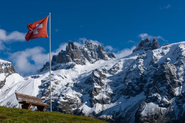 A swiss flag on a mountain