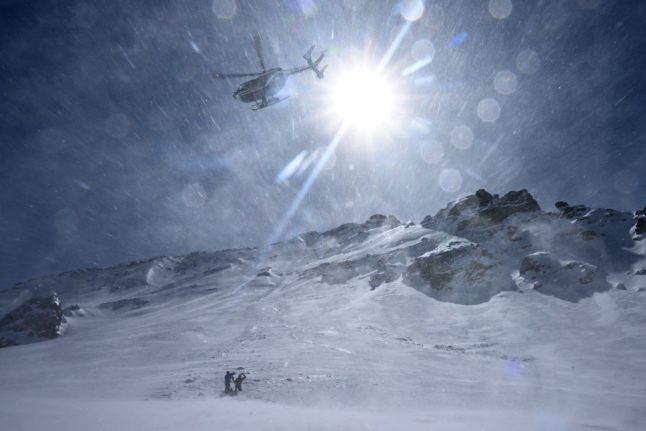 A French mountain gendarme and a pretend victim are evacuated by helicopter during an avalanche exercise on March 16, 2023, near Briancon, French Alps.