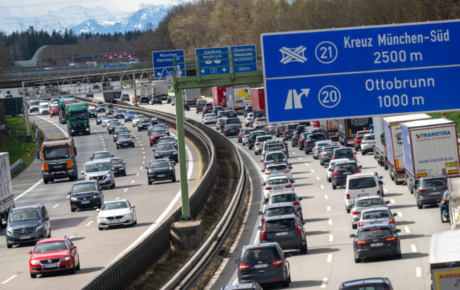 Cars and lorries drive on the A99 motorway at the Munich South motorway junction.