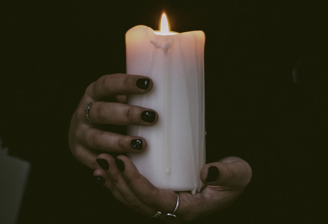 A witch holds a candle
