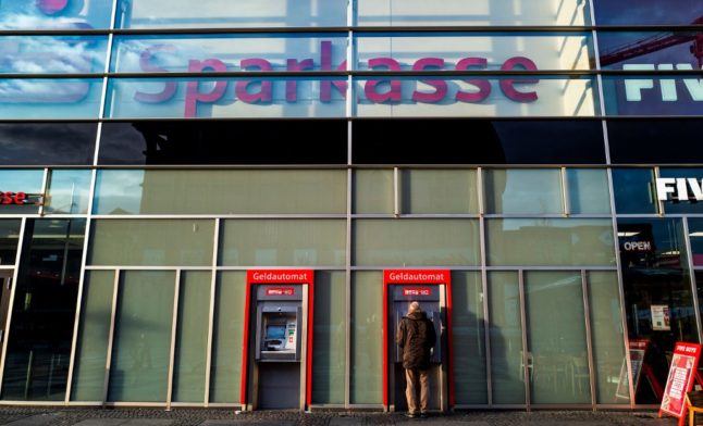 A man uses an ATM machine at a branch of Germany's Sparkasse bank in Berlin.