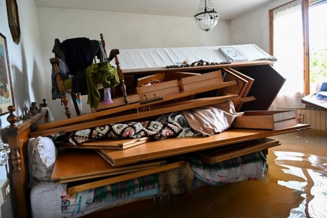Furniture is piled up on a bed of a flooded house on May 20, 2023 in the village of Ghibullo, near Ravenna.