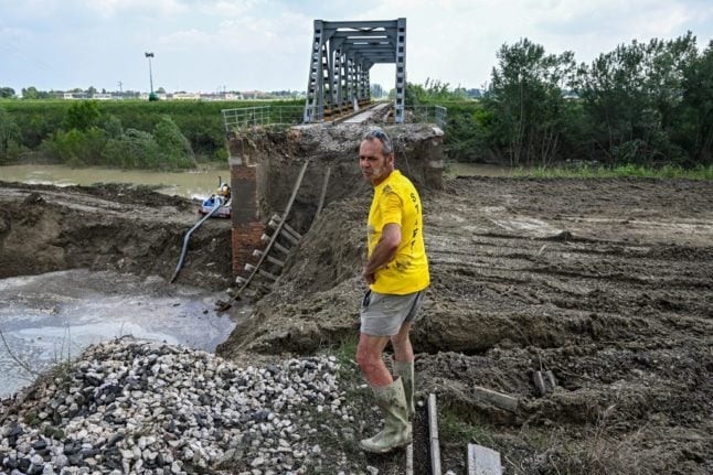 A man stands by a collapsed railway bridge washed away by floodwaters in Sant'Agata sul Santerno on May 21, 2023.